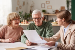 Pareja de la tercera edad consultando con una especialista en trámites de herencias